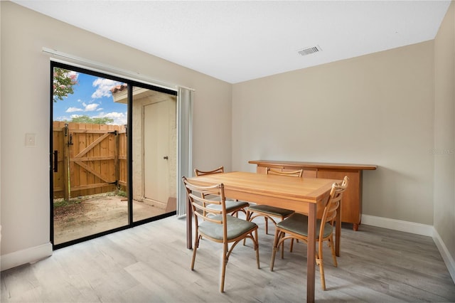 dining room with a barn door and light wood-type flooring