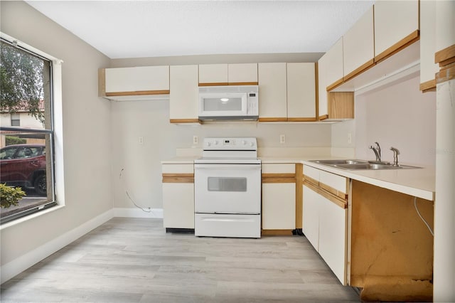 kitchen featuring sink, light hardwood / wood-style floors, white cabinets, and white appliances