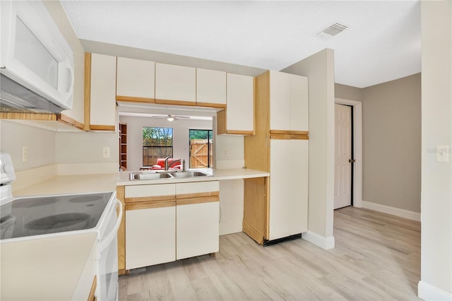 kitchen with white appliances, white cabinets, sink, light wood-type flooring, and ceiling fan