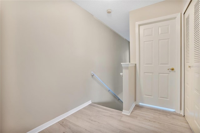 staircase featuring lofted ceiling and wood-type flooring