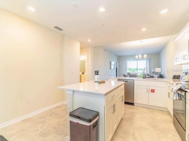 kitchen with stainless steel appliances, a center island, white cabinets, light tile floors, and pendant lighting