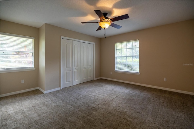 unfurnished bedroom featuring ceiling fan, carpet floors, a closet, and a textured ceiling