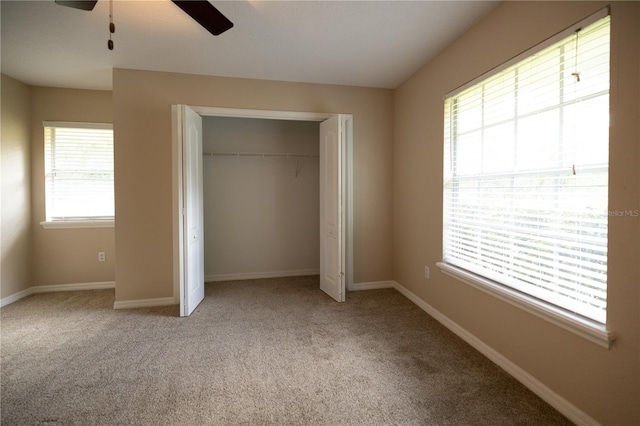 unfurnished bedroom featuring light colored carpet, a closet, and ceiling fan