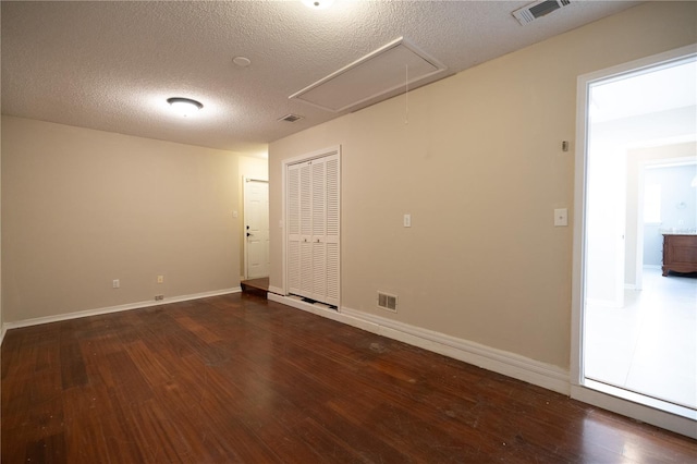 unfurnished room featuring dark hardwood / wood-style floors and a textured ceiling