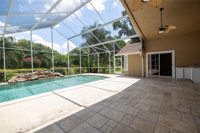 view of pool featuring ceiling fan, glass enclosure, and a patio area