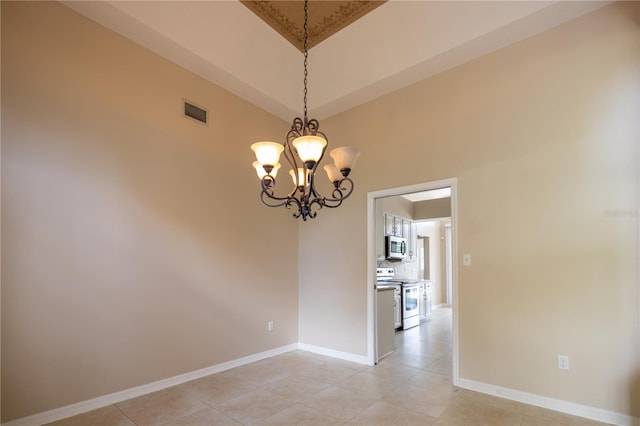 spare room with light tile patterned floors and an inviting chandelier