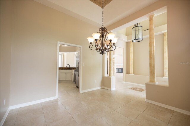 unfurnished dining area with light tile patterned floors, sink, and ornate columns