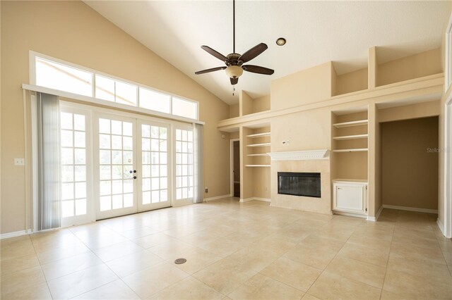 unfurnished living room with built in shelves, french doors, light tile patterned floors, ceiling fan, and a fireplace