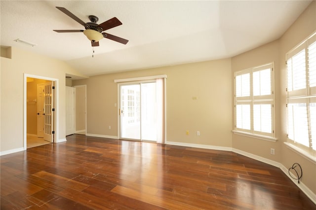 spare room with dark hardwood / wood-style flooring, vaulted ceiling, and ceiling fan