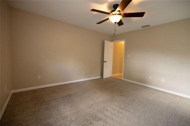 carpeted spare room with ceiling fan