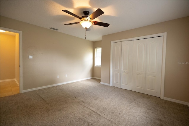 unfurnished bedroom with light carpet, ceiling fan, and a closet