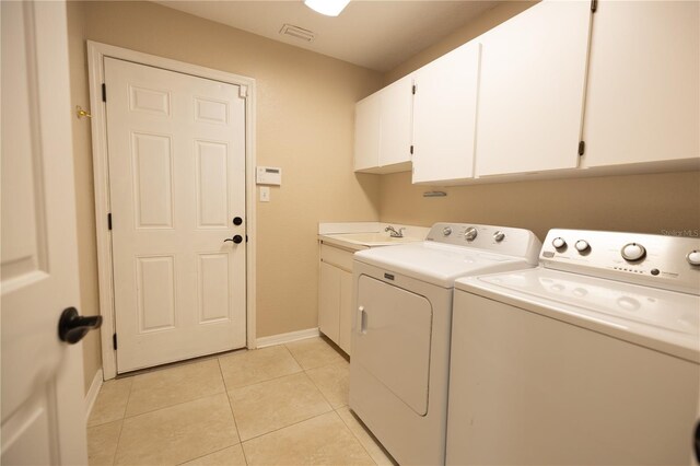 washroom featuring cabinets, washing machine and dryer, sink, and light tile patterned flooring