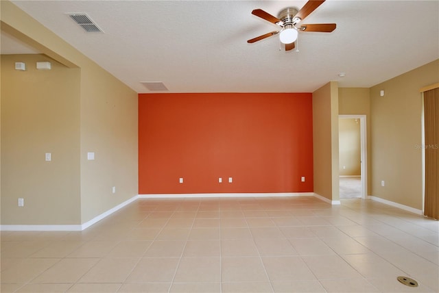 tiled spare room with a textured ceiling and ceiling fan