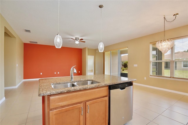 kitchen featuring pendant lighting, dishwasher, an island with sink, sink, and light stone countertops