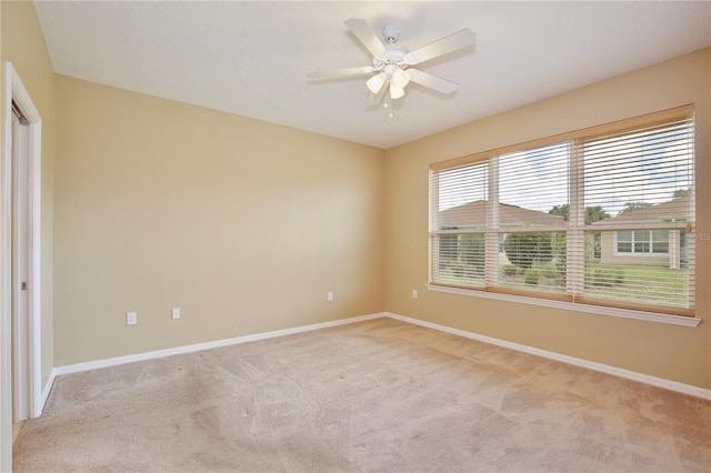 carpeted spare room with ceiling fan