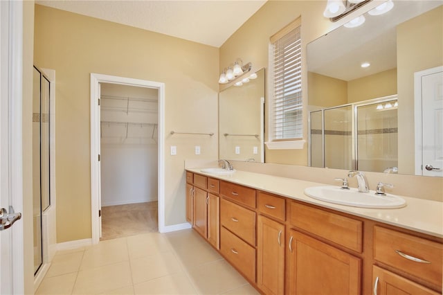 bathroom featuring vanity, tile patterned flooring, and walk in shower