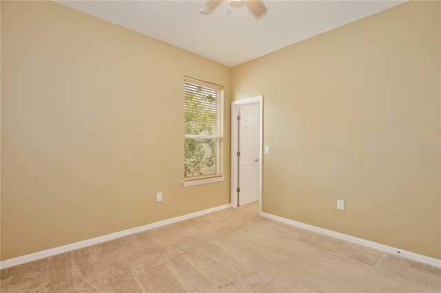 carpeted spare room featuring ceiling fan