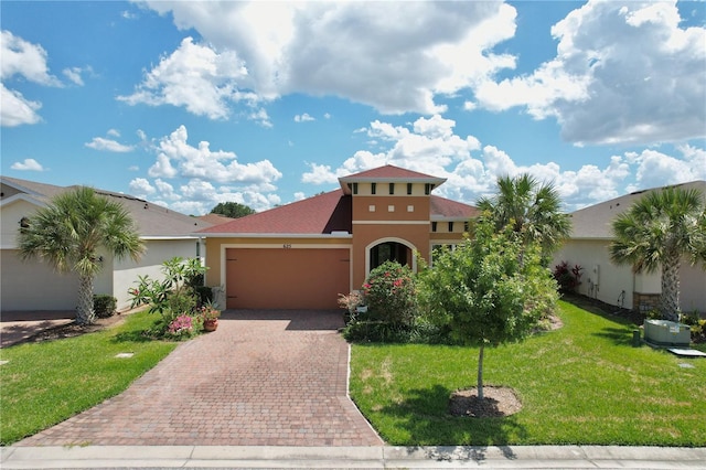 mediterranean / spanish-style home featuring a garage and a front yard