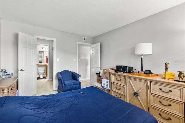 carpeted bedroom featuring ensuite bath