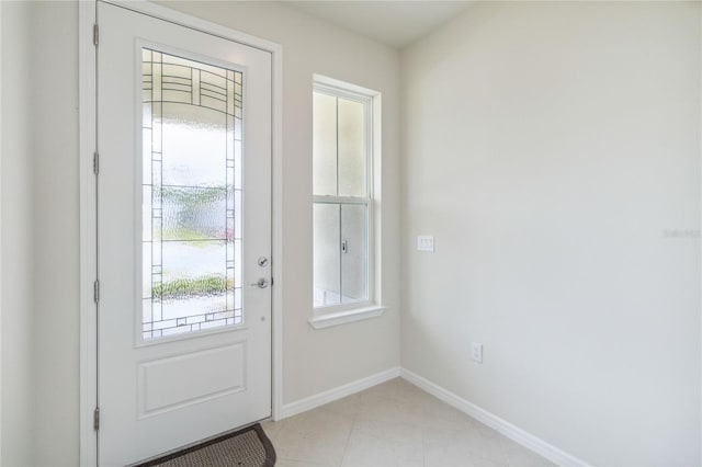 doorway to outside with light tile patterned floors