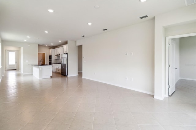 unfurnished living room with light tile patterned floors and sink