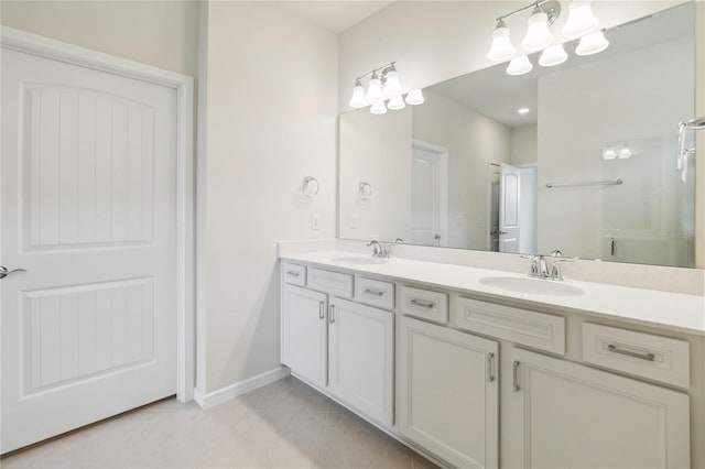 bathroom with tile patterned floors, vanity, a shower with shower door, and an inviting chandelier