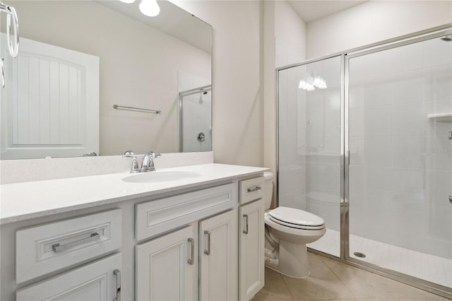 bathroom with toilet, vanity, tile patterned floors, and a shower with shower door