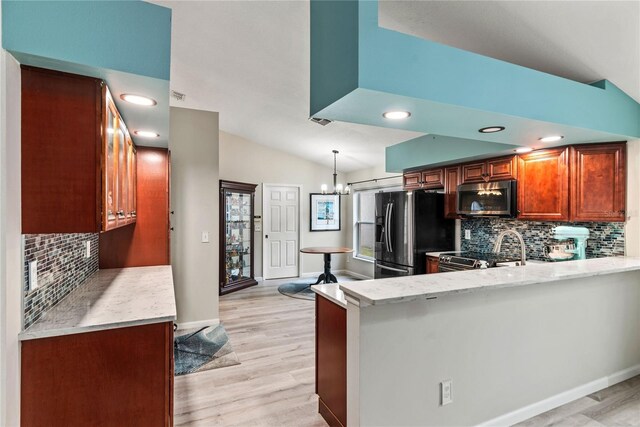 kitchen featuring lofted ceiling, appliances with stainless steel finishes, backsplash, and light hardwood / wood-style floors