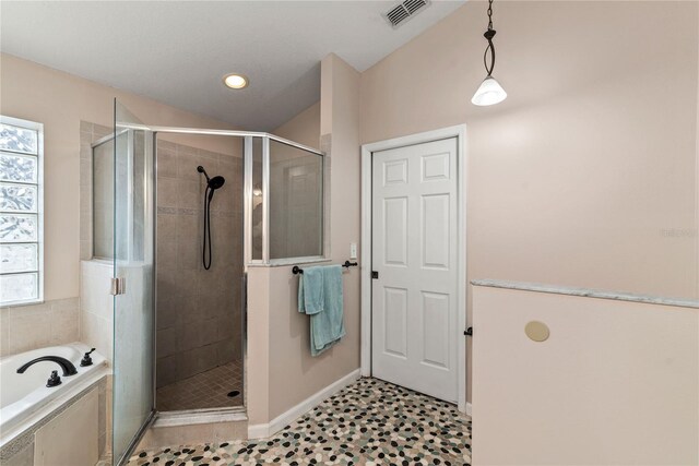 bathroom with vaulted ceiling, a healthy amount of sunlight, and plus walk in shower