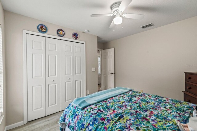 bedroom featuring ceiling fan, a closet, and light wood-type flooring