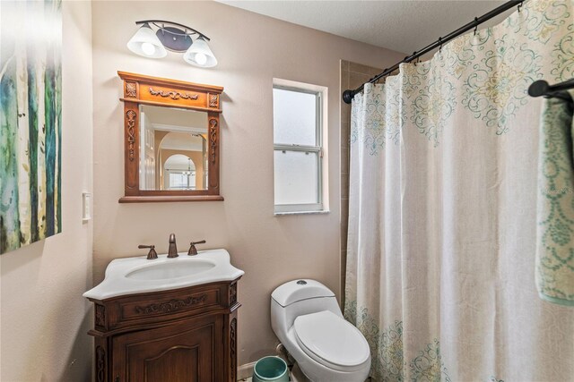 bathroom with a textured ceiling, vanity, toilet, and curtained shower