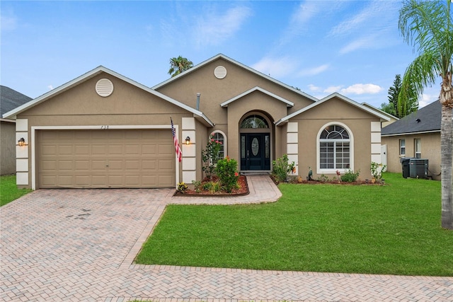 ranch-style house featuring a garage, a front yard, and central AC unit