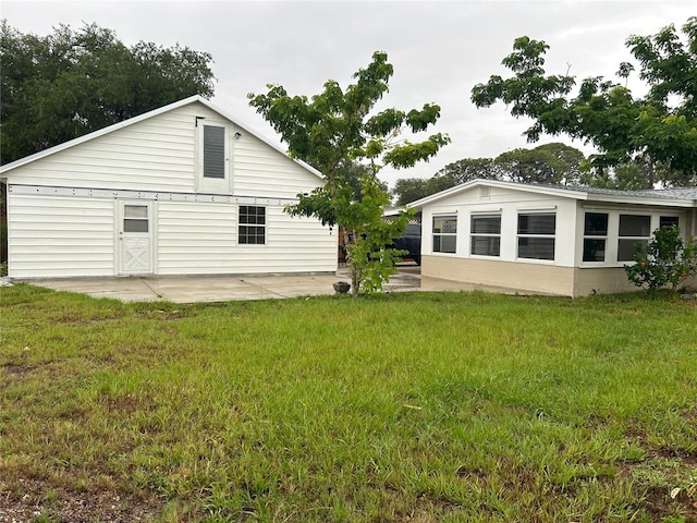 rear view of property featuring a yard and a patio