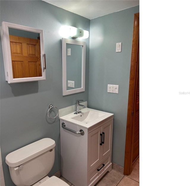 half bathroom featuring vanity, toilet, and tile patterned floors