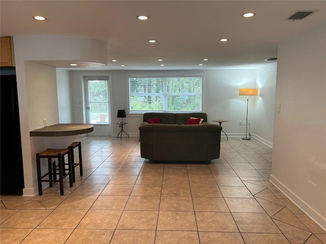 living room with light tile patterned floors, baseboards, visible vents, and recessed lighting