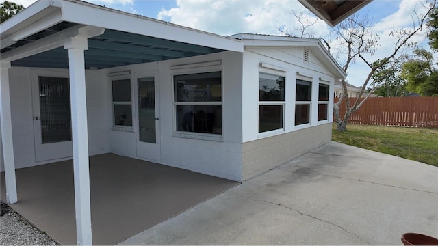 exterior space featuring an attached carport, a patio area, and fence