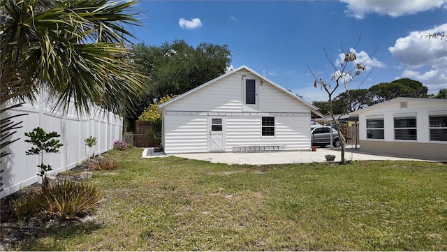 back of house featuring fence, a lawn, and a patio