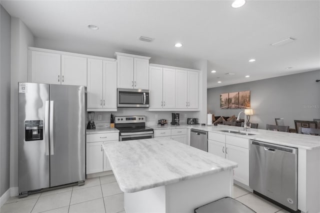 kitchen with white cabinetry, sink, a kitchen island, and stainless steel appliances