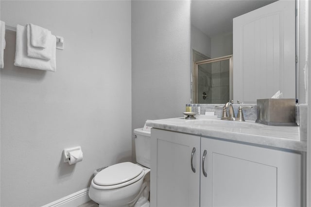 bathroom featuring vanity, toilet, and a shower with shower door