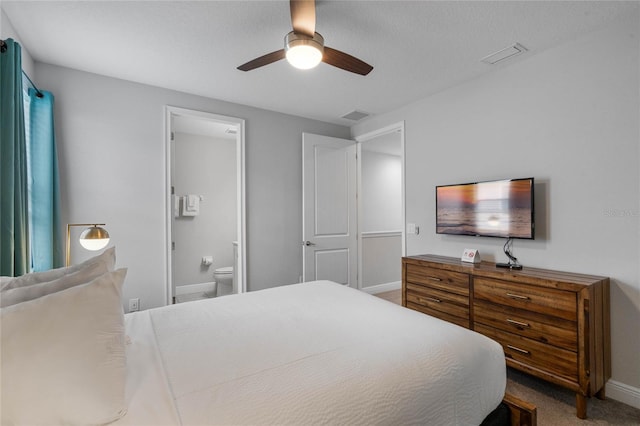 bedroom with carpet flooring, ceiling fan, ensuite bathroom, and a textured ceiling