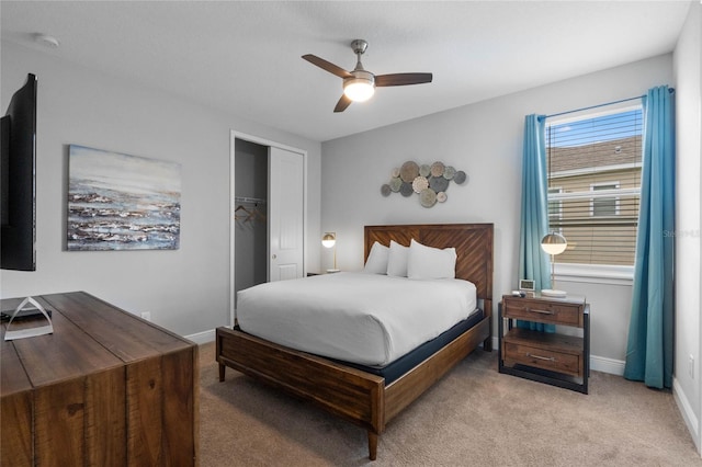 carpeted bedroom with ceiling fan and a closet