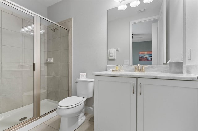 bathroom with tile patterned flooring, vanity, toilet, and a shower with shower door