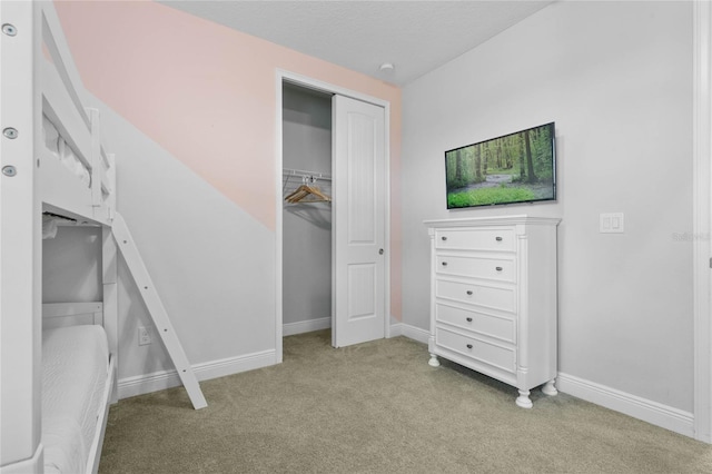 unfurnished bedroom with light colored carpet and a closet