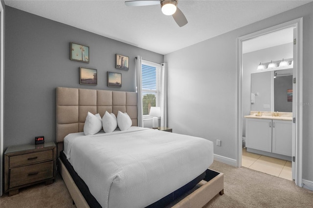 carpeted bedroom with ensuite bathroom, sink, and ceiling fan