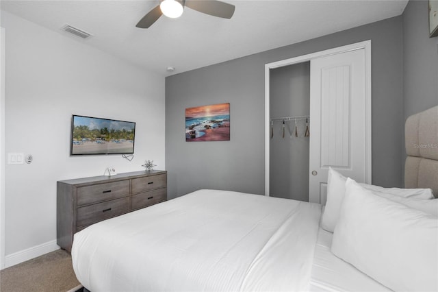 bedroom featuring ceiling fan, light colored carpet, and a closet