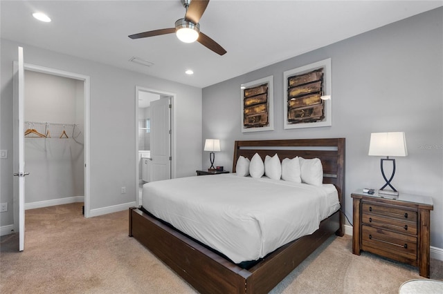 carpeted bedroom with connected bathroom, a closet, a spacious closet, and ceiling fan