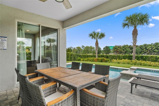 view of patio / terrace with ceiling fan and a swimming pool with hot tub