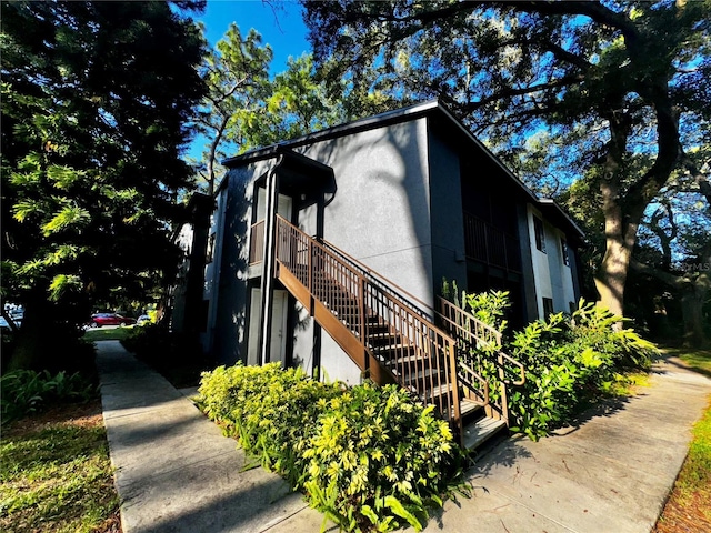 view of property exterior with stairway and stucco siding