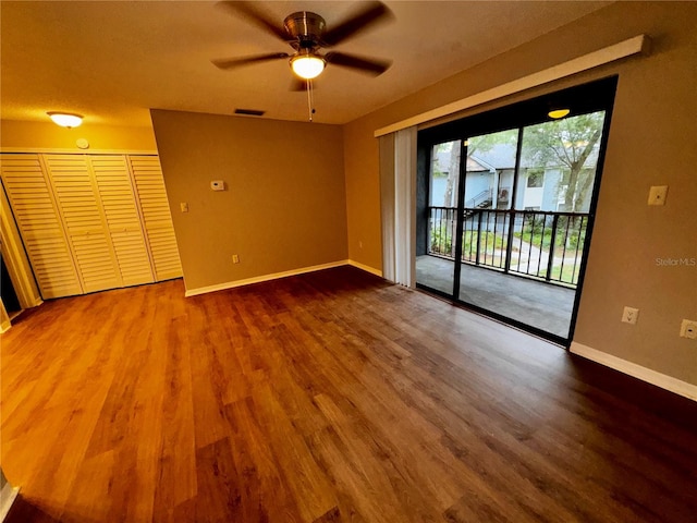 unfurnished room with ceiling fan, wood finished floors, visible vents, and baseboards