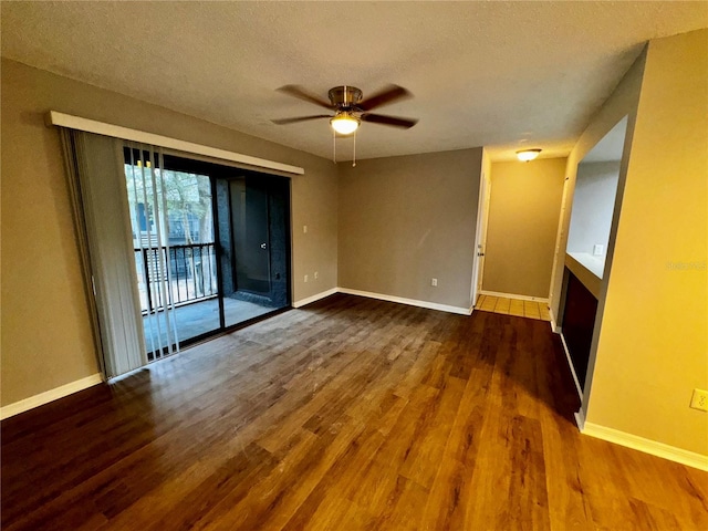 empty room featuring ceiling fan, a textured ceiling, baseboards, and wood finished floors